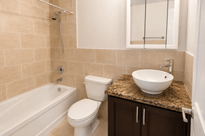 Hamilton apartment for rent - A bathroom with a white toilet, sink, and bathtub.