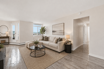 Hamilton apartment for rent - A living room with a white couch, a coffee table, and a large painting on the wall.