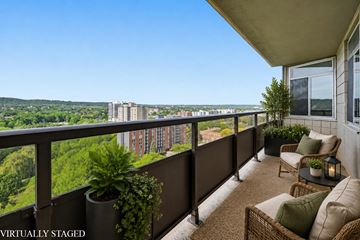 Hamilton apartment for rent - A balcony with a table and chairs overlooking a cityscape.