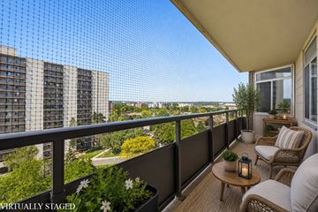 Hamilton apartment for rent - A balcony with a table, chairs, and a lantern with a view of a city in the background.