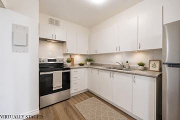 Hamilton apartment for rent - A kitchen with white cabinets and a stainless steel refrigerator.