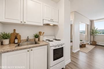 Hamilton apartment for rent - A kitchen with white cabinets and a stove top oven.