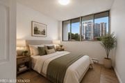 Hamilton apartment for rent - A bedroom with a large bed and a potted plant.