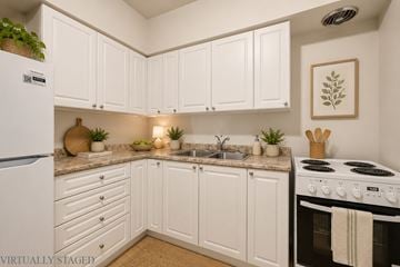 Hamilton apartment for rent - A kitchen with white cabinets and a stove top oven.