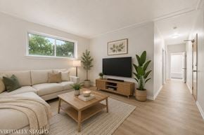 Hamilton apartment for rent - A living room with a white couch, a wooden coffee table, and a flat-screen TV.