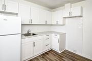 St. Catharines apartment for rent - A kitchen with white cabinets and a white fridge.