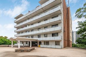 Hamilton apartment for rent - A large white building with a red brick base and a white canopy.