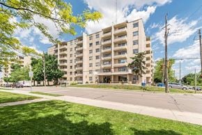 Hamilton apartment for rent - A large apartment building with a grassy area in front.