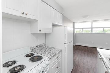 Dundas apartment for rent - A kitchen with white cabinets and a granite countertop.