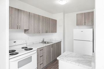 Hamilton apartment for rent - A kitchen with a white stove top oven, white counter top, and white refrigerator.