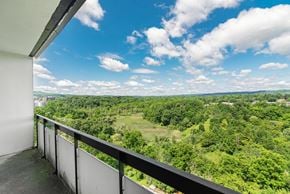 Hamilton apartment for rent - A balcony overlooks a lush green landscape.