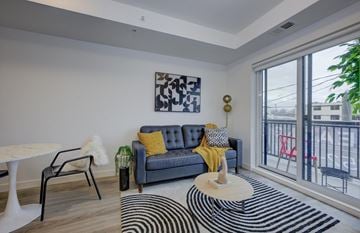 Kitchener apartment for rent - A living room with a grey couch and a yellow throw.