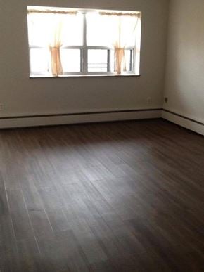 Hamilton apartment for rent - A room with a window and wooden flooring.