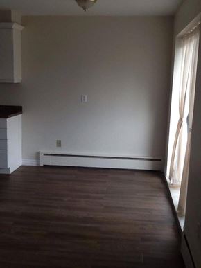 Hamilton apartment for rent - A room with wooden floors and white walls.