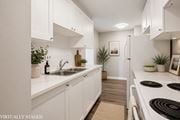Hamilton apartment for rent - A kitchen with white cabinets and a stove top oven.