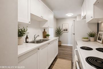 Hamilton apartment for rent - A kitchen with white cabinets and a stove top oven.