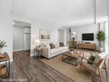 Hamilton apartment for rent - A living room with a white couch, a coffee table, and a television.