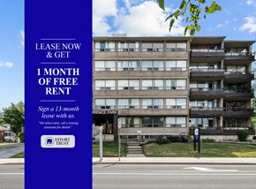 Hamilton apartment for rent - A large building with a blue sign offering free rent for the first month.