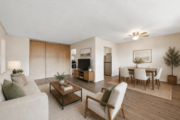 Hamilton apartment for rent - A living room with a grey couch, a coffee table, a chair, a potted plant, and a dining table set up.