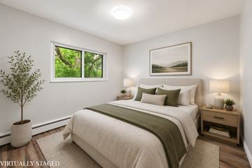 Hamilton apartment for rent - A bedroom with a large bed and a potted plant.