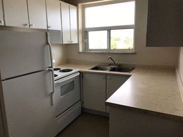 Hamilton apartment for rent - A kitchen with white appliances and a window.