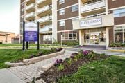 Kitchener apartment for rent - The entrance to the Alexandrian apartment complex is shown with a sign and flower bed in front.