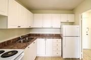 Kitchener apartment for rent - A kitchen with white cabinets and a white refrigerator.