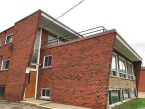 Hamilton apartment for rent - A red brick building with a brown door and windows.