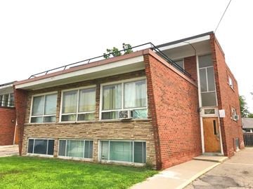 Hamilton apartment for rent - A red brick building with a balcony and a door.