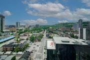Hamilton apartment for rent - A cityscape with buildings, roads, and cars under a partly cloudy sky.