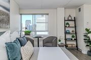 Hamilton apartment for rent - A well-lit bedroom with a large bed and a city view through the window.