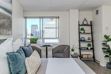 Hamilton apartment for rent - A well-lit bedroom with a large bed and a city view through the window.