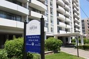 Hamilton apartment for rent - A sign for Bay 100 Apartments stands in front of a white building.