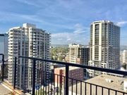 Hamilton apartment for rent - A cityscape with buildings and a balcony in the foreground.