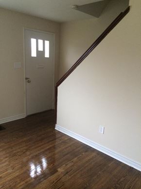 Cobourg apartment for rent - A room with a wooden floor and a white door.