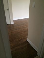 Cobourg apartment for rent - A hallway with wood floors and white walls.