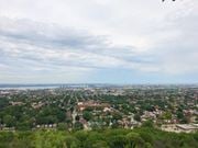 Hamilton apartment for rent - A cityscape with buildings and trees under a cloudy sky.