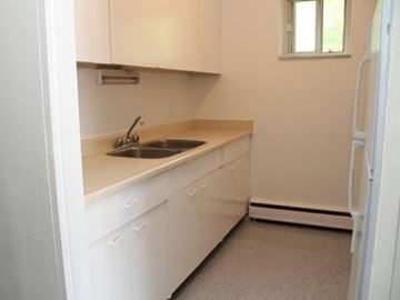 Hamilton apartment for rent - A kitchen with white cabinets and a window.