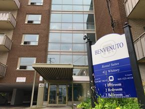 Hamilton apartment for rent - A sign for Benvenuto Rental Suites stands in front of a building.