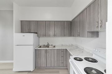 Hamilton apartment for rent - A kitchen with a white stove top oven and a white refrigerator.