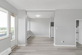 Hamilton apartment for rent - A spacious, empty room with light wood flooring and white walls.