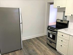 Kitchener apartment for rent - A kitchen with a refrigerator, oven, and cabinets.