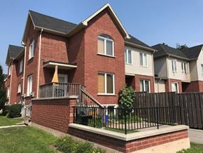 Hamilton apartment for rent - A red brick house with a black fence in front.