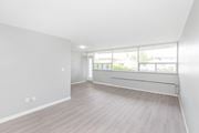 Hamilton apartment for rent - A spacious room with light wood flooring and large windows.
