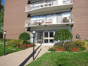 Dundas apartment for rent - A building with a balcony and a garden in front.