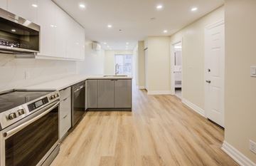 Hamilton apartment for rent - A modern kitchen with white cabinets and stainless steel appliances.