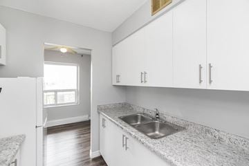 Stoney Creek apartment for rent - A kitchen with white cabinets and a granite countertop.