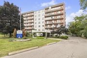 Stoney Creek apartment for rent - A large apartment building with a flag on top and a sign in front.