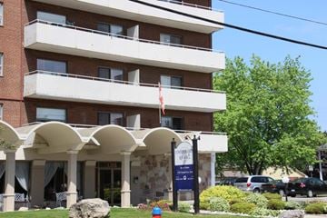 Hamilton apartment for rent - A building with a sign that says "Welcome to Evergreen Apartments" in front of it.