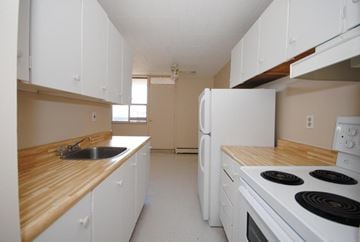 Stoney Creek apartment for rent - A kitchen with white cabinets and a wooden counter top.